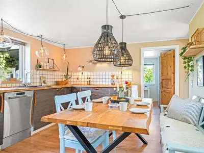 a kitchen and dining room with a wooden table and chairs at Holiday Home Cillvur - 8km from the sea by Interhome in Thisted