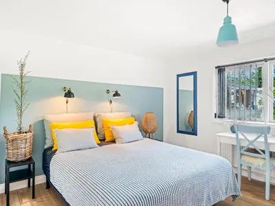 a bedroom with a bed with yellow pillows and a desk at Holiday Home Cillvur - 8km from the sea by Interhome in Thisted