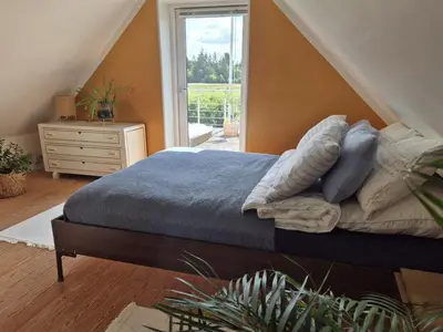 a bedroom with a bed and a dresser and a window at Holiday Home Cillvur - 8km from the sea by Interhome in Thisted