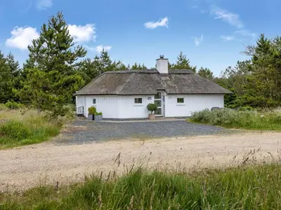 a white house with a roof on a dirt road at Holiday Home Pihla - 1-1km from the sea by Interhome in Fjerritslev