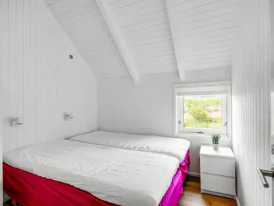 a white bedroom with a large bed with a window at Holiday Home Pihla - 1-1km from the sea by Interhome in Fjerritslev