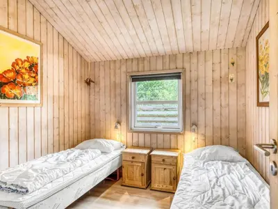 two beds in a room with a window at Holiday Home Ane - 800m from the sea by Interhome in Fjerritslev