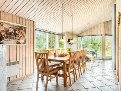 a dining room with a wooden table and chairs at Holiday Home Ane - 800m from the sea by Interhome in Fjerritslev