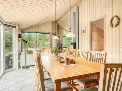 a dining room with a wooden table and chairs at Holiday Home Ane - 800m from the sea by Interhome in Fjerritslev