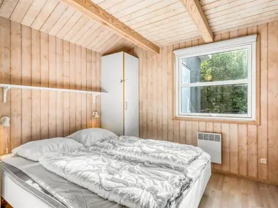 a bed in a room with a window at Holiday Home Ane - 800m from the sea by Interhome in Fjerritslev