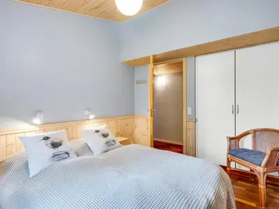 a bedroom with a bed and a chair at Holiday Home Zölestine - from the sea by Interhome in Fjerritslev