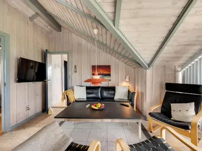 a living room with a couch and a table at Holiday Home Angelie - 400m from the sea by Interhome in Harboør
