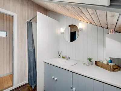 a bathroom with a sink and a mirror at Holiday Home Angelie - 400m from the sea by Interhome in Harboør