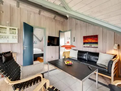 a living room with a couch and a table at Holiday Home Angelie - 400m from the sea by Interhome in Harboør