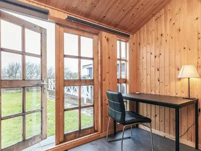 a desk with a chair in a room with windows at 7 person holiday home in Vestervig-By Traum in Vestervig