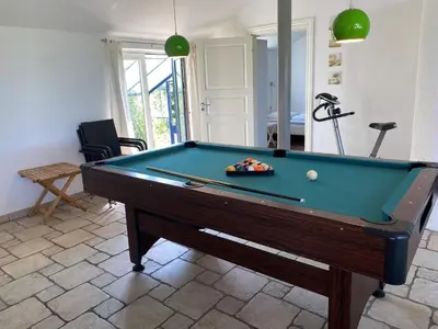 a pool table in a living room with a pool at Light-filled Retreat in Boddum - By Traum Ferienwohnungen in Boddum