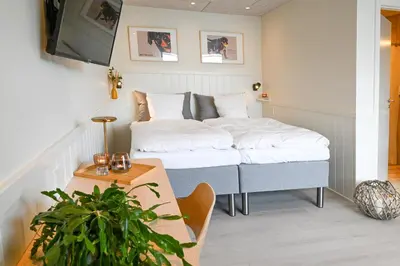 a bedroom with a bed with a table and a tv at Rold Gl Kro in Arden