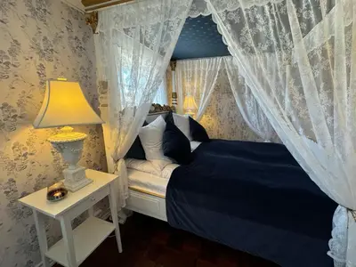 a bedroom with a blue bed with a canopy at Rold Gl Kro in Arden