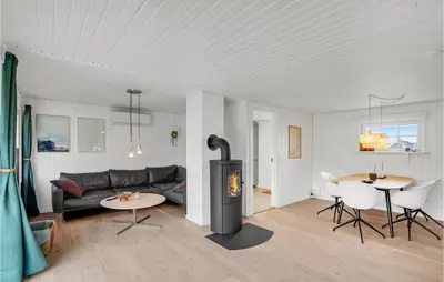 a living room with a fireplace and a couch and a table at 2 Bedroom Stunning Home In Harboøre in Harboør