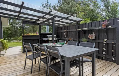a wooden deck with a table and chairs under a pergola at 4 Bedroom Lovely Home In Vestervig in Vestervig