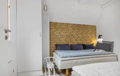 a bedroom with a bed and a brick wall at 3 Bedroom Stunning Home In Højslev in Højslev
