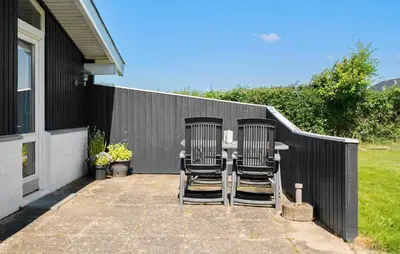 two chairs sitting at a table in front of a fence at 3 Bedroom Beautiful Home In Vinderup in Vinderup