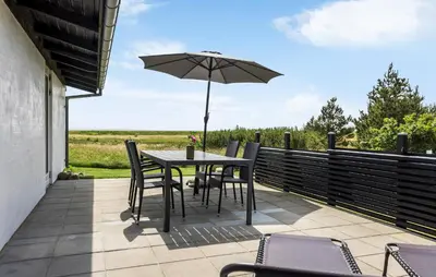 a table and chairs with an umbrella on a patio at Lovely Home In Hurup Thy With Wifi in Sindrup