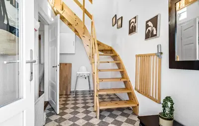 a wooden staircase in a room with a checkered floor at 4 Bedroom Nice Home In Harboøre in Harboør