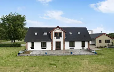a large white house with a black roof at 5 Bedroom Beautiful Home In Brovst in Brovst