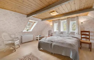 a bedroom with a bed and two chairs in a room at 5 Bedroom Beautiful Home In Brovst in Brovst