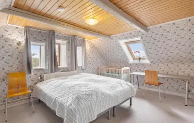a bedroom with a bed and a table and two chairs at 5 Bedroom Beautiful Home In Brovst in Brovst
