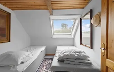 a small bedroom with a bed and a window at 5 Bedroom Beautiful Home In Brovst in Brovst
