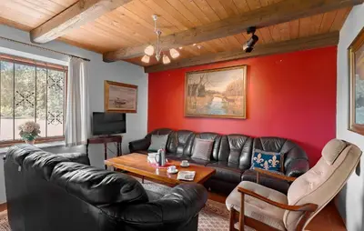 a living room with a leather couch and a table at 5 Bedroom Beautiful Home In Brovst in Brovst