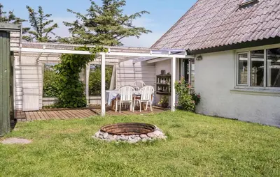 a patio with a table and chairs in a yard at Nice Home In Harboøre With Wifi in Harboør
