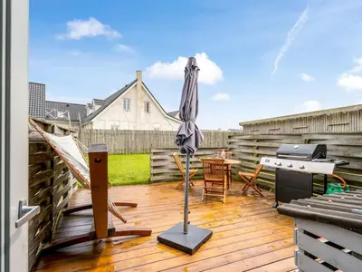 a patio with an umbrella and a table and a piano at Apartment Hansa - 300m from the sea by Interhome in Torsted