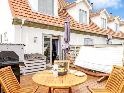 a patio with a table and chairs and an umbrella at Apartment Hansa - 300m from the sea by Interhome in Torsted