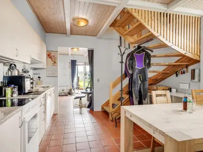 a kitchen with white counters and wooden ceilings at Apartment Hansa - 300m from the sea by Interhome in Torsted