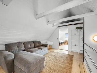 a living room with a couch and a table at Holiday Home Darja - 300m from the sea by Interhome in Thyborøn