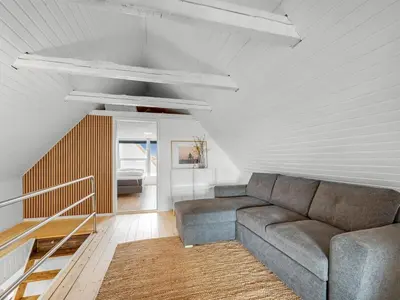 a living room with a couch and a staircase at Holiday Home Darja - 300m from the sea by Interhome in Thyborøn