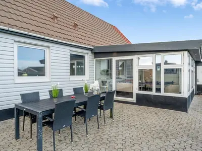 a patio with a table and chairs and a house at Holiday Home Darja - 300m from the sea by Interhome in Thyborøn