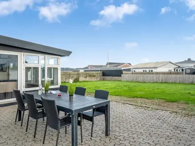 a black table and chairs on a patio at Holiday Home Darja - 300m from the sea by Interhome in Thyborøn