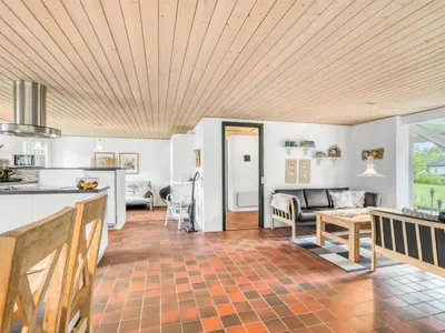 a kitchen and living room with a wooden ceiling at Holiday Home Lyra - 500m to the fjord by Interhome in Øsløs