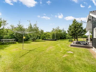 a large yard with a picnic table and benches at Holiday Home Lissi - 3-5km from the sea by Interhome in Brovst