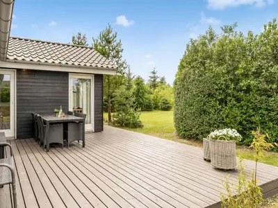 a wooden deck with a table on a house at Holiday Home Lissi - 3-5km from the sea by Interhome in Brovst