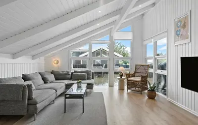 a living room with a couch and a tv at Awesome Home In Løkken With Kitchen in Løkken