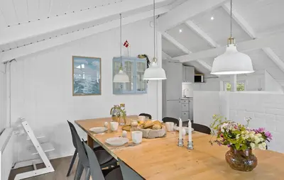 a kitchen and dining room with a table and chairs at Awesome Home In Løkken With Kitchen in Løkken