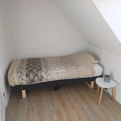 a small bedroom with a bed and a table at Vakantiewoning Denemarken in Års