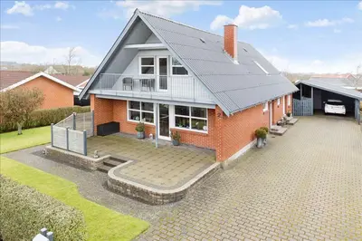 a red brick house with a black roof at Rødkælkevej's B&B in Hurup