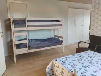 two bunk beds in a room with a table at Rødkælkevej's B&B in Hurup