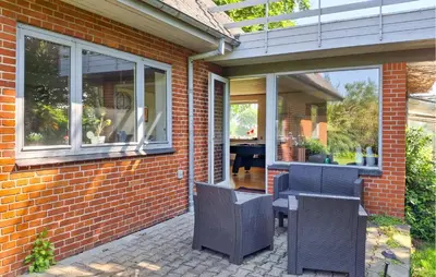 a patio with chairs and a table and windows at 2 Bedroom Stunning Home In Erslev in Erslev