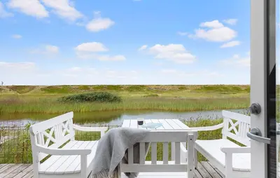 a white table and chairs on a porch with a lake at 3 Bedroom Stunning Home In Vestervig in Vestervig