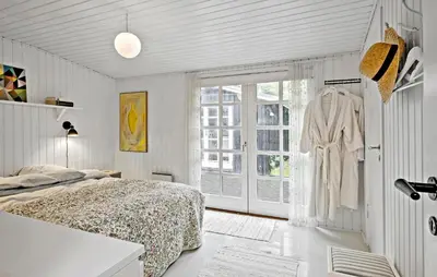 a white bedroom with a bed and a window at Beautiful Home In Blokhus in Blokhus