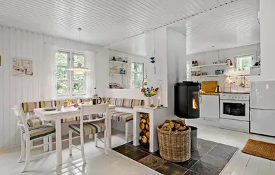 a kitchen with a table and chairs and a stove at Beautiful Home In Blokhus in Blokhus