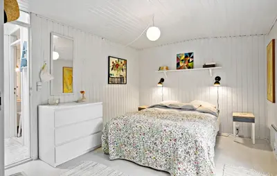 a white bedroom with a bed and a dresser and lights at Beautiful Home In Blokhus in Blokhus