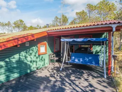 a green house with a porch with a blue canopy at 4 person holiday home in Thisted-By Traum in Thisted